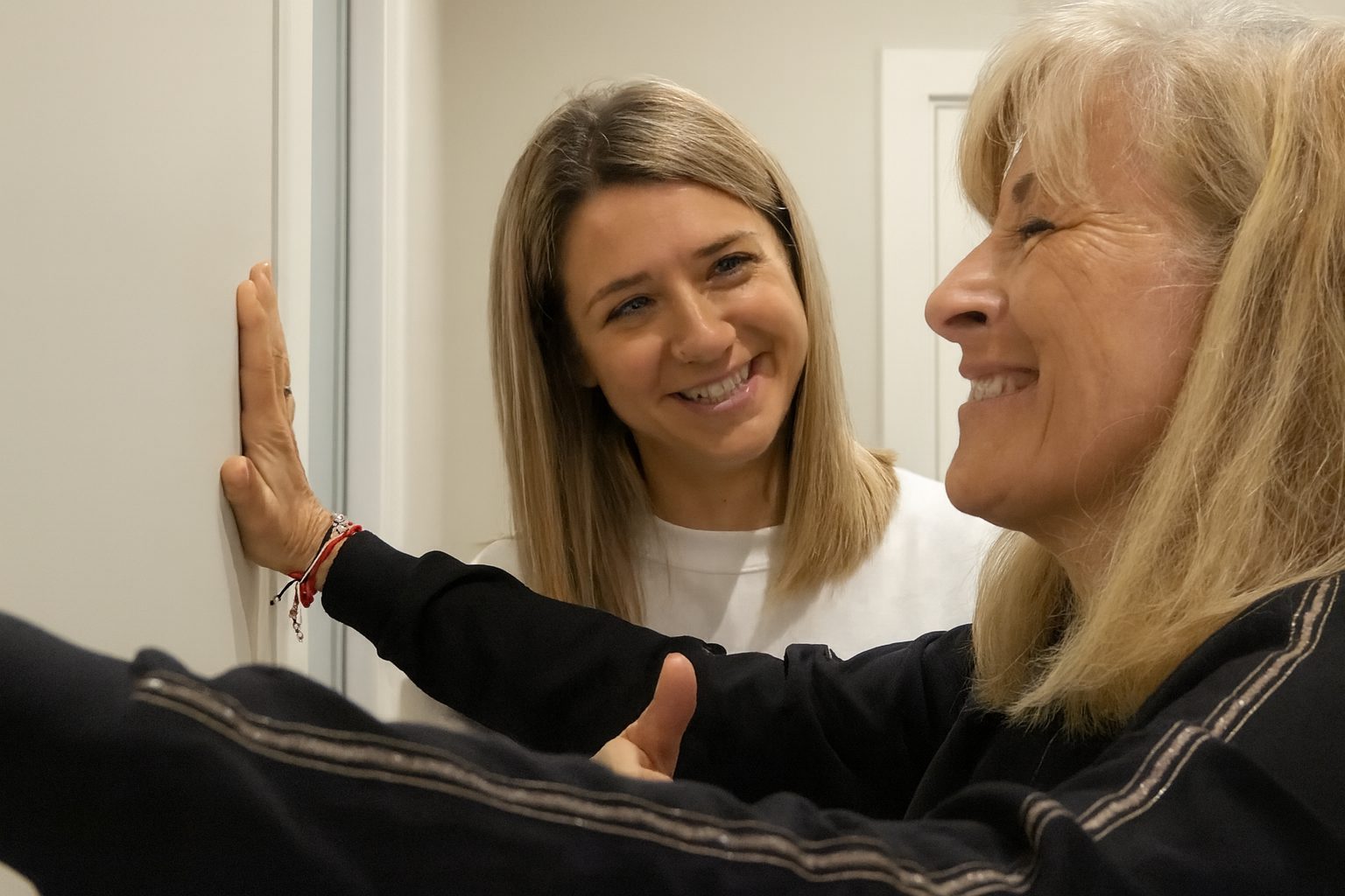 Persona mayor sonriendo durante una sesión de fisioterapia en casa