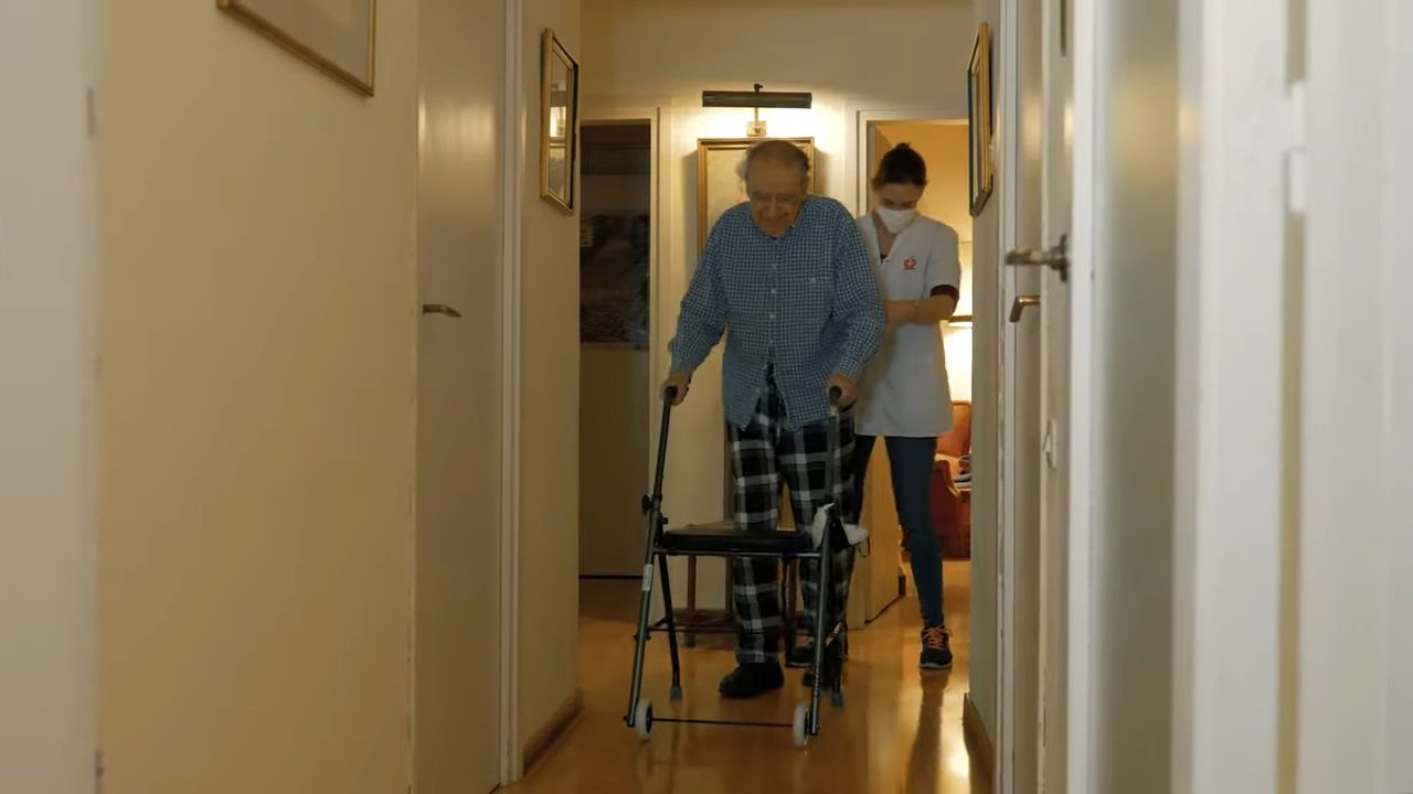 Persona mayor practicando ejercicios de equilibrio con su fisioterapeuta para prevenir caídas.