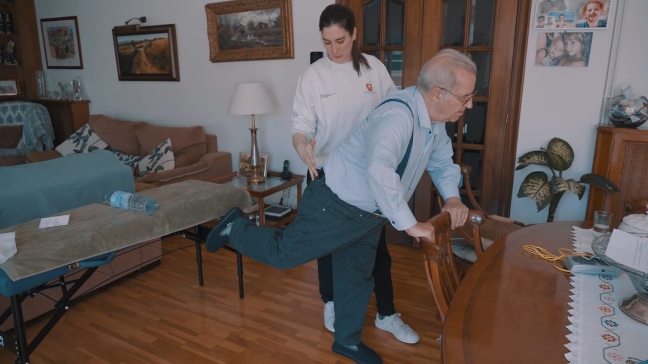 Fisioterapeuta enseñando un ejercicio de descompresión para hernia discal a un paciente en casa