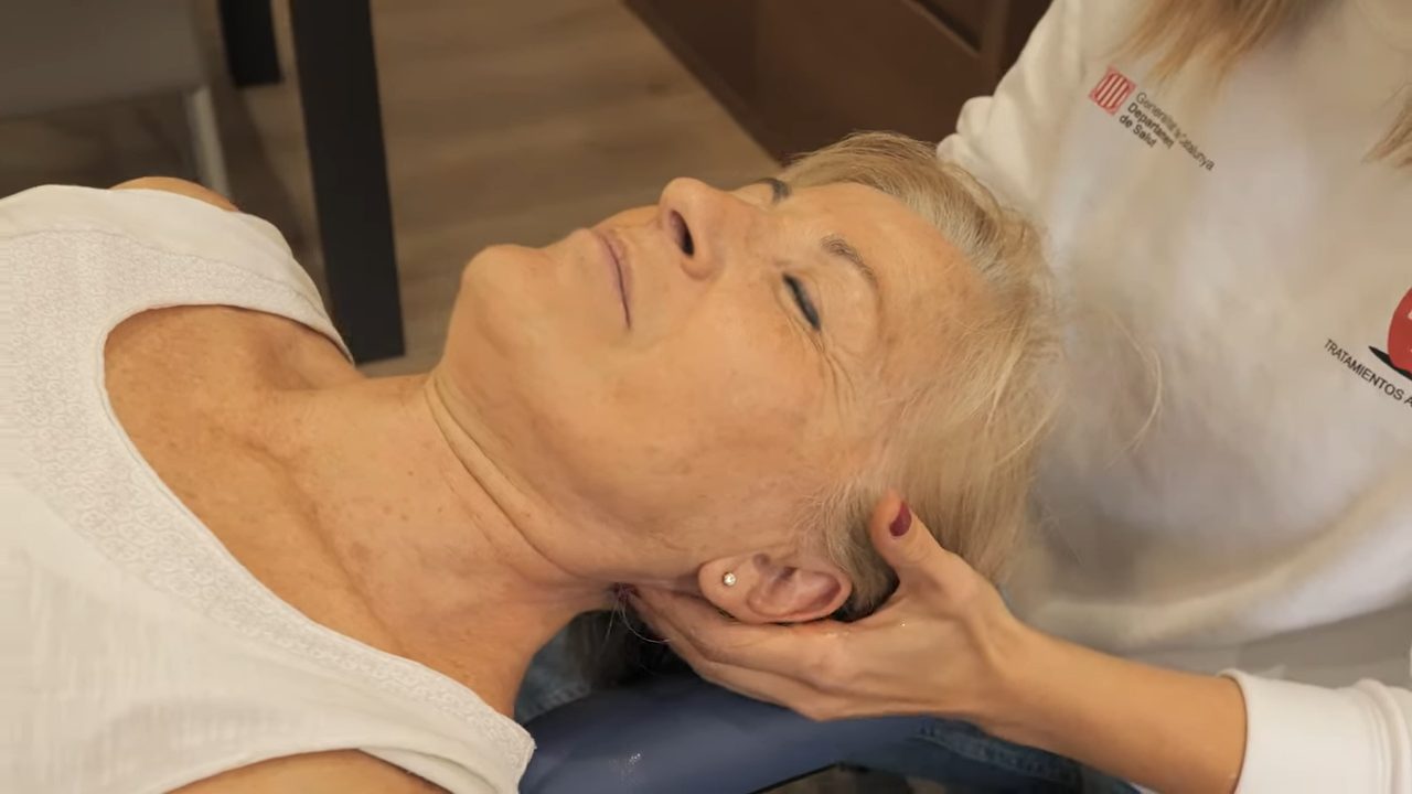 Mujer relajada recibiendo un masaje de drenaje linfático en casa